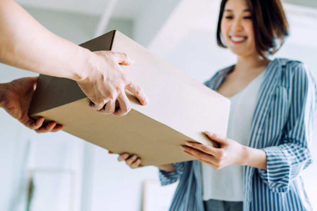 Close up of a courier person making a delivery to a customer at home. Providing a swift express delivery straight into customer's hands Close up of a courier person making a delivery to a customer at home. Providing a swift express delivery straight into customer's hands